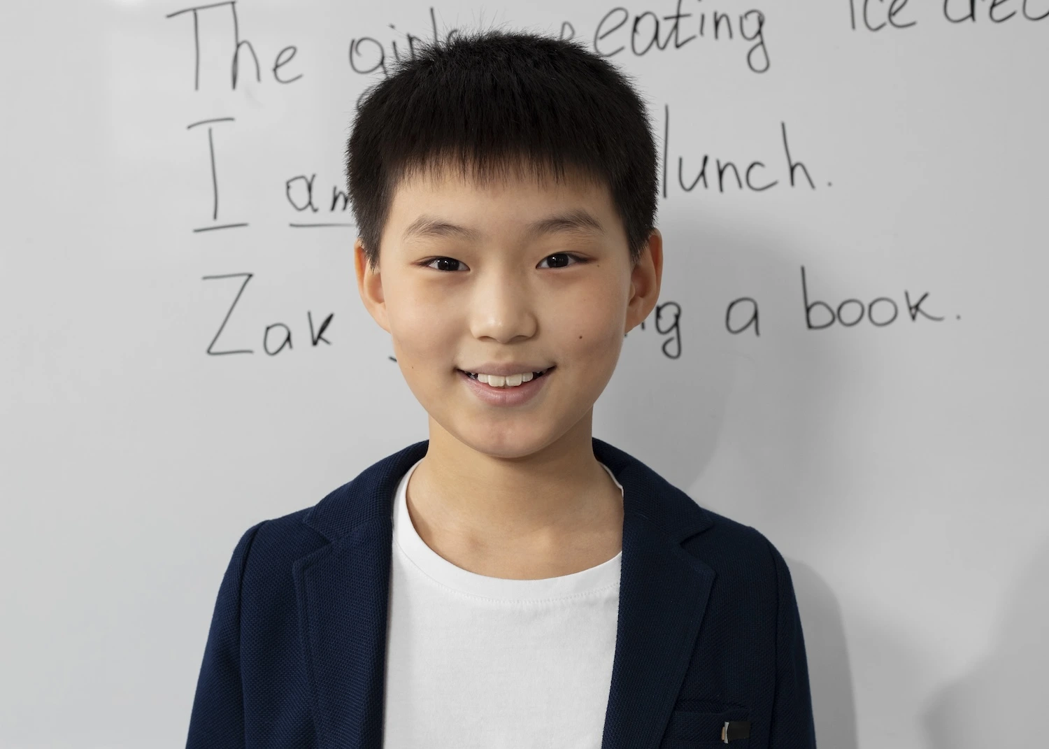 Smiling boy in front of a whiteboard